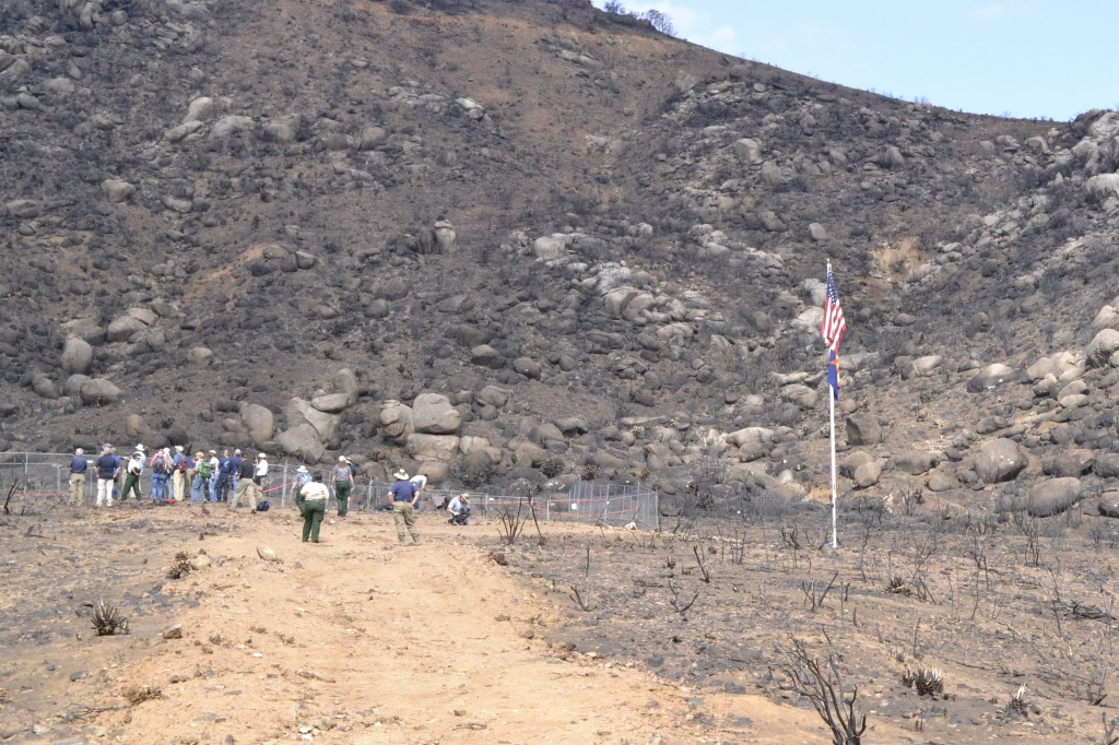 The media gathers around a fenced area where the Granite Mountain Hotshots deployed their shelters on June 30, 2013.